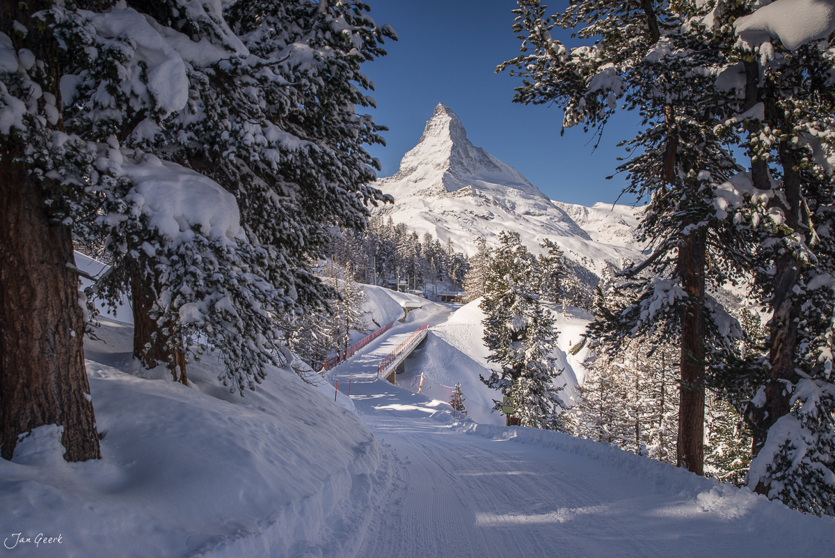 Verschneiter Wanderweg durch Winterwald mit Blick auf Matterhorn bei Zermatt, Wallis Schweiz – Jan Geerk Fotograf Basel