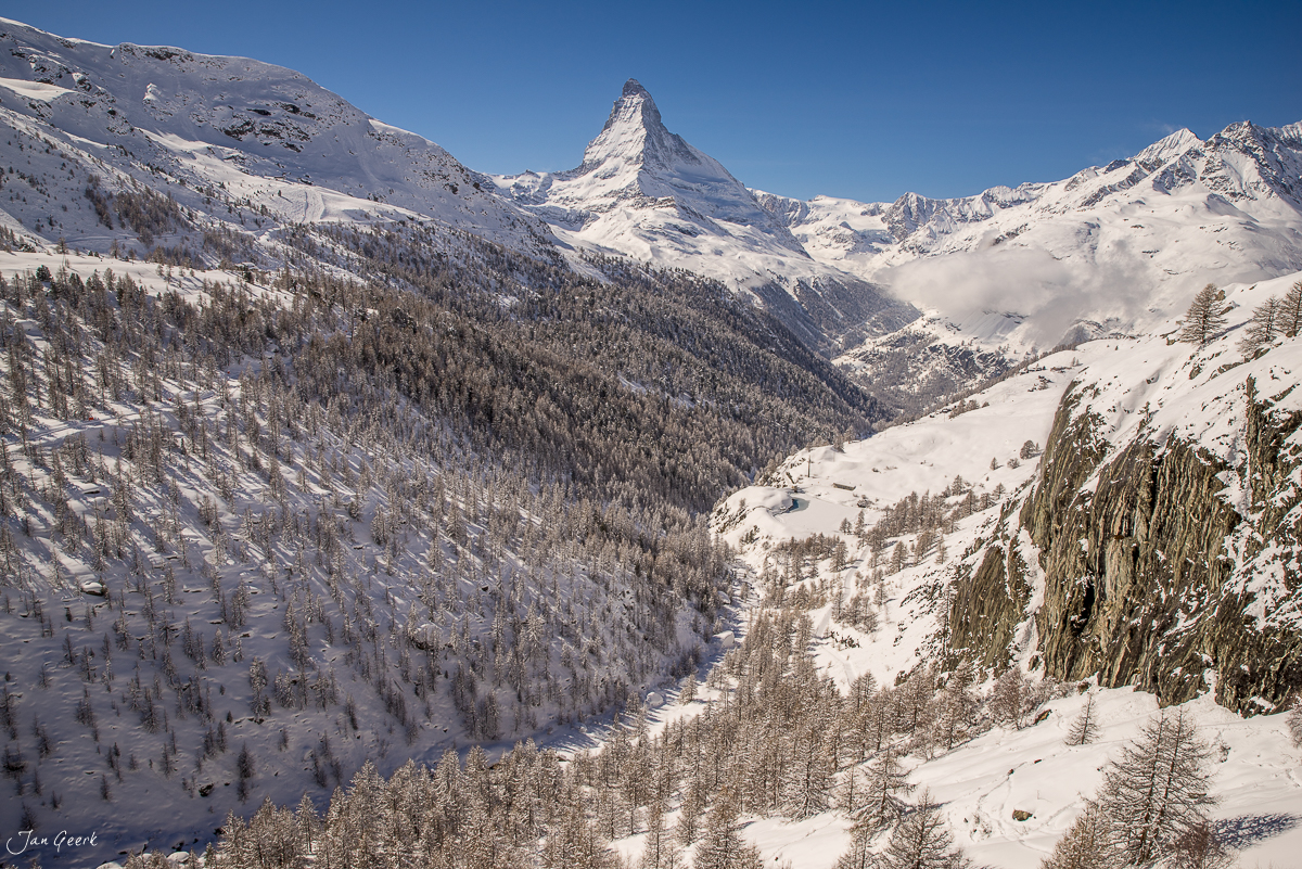 Schneebedecktes Alpental mit Matterhorn im Hintergrund, Lärchenwälder im Winter bei Zermatt, Schweiz – Jan Geerk Fotograf Basel