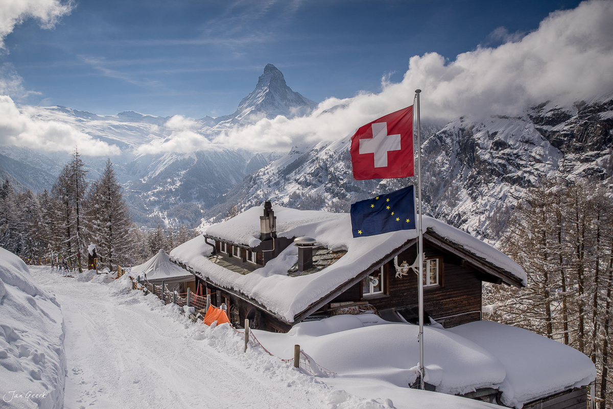 Schweizer Hütte mit Flaggen am Riffelalp mit Matterhorn Winterlandschaft Wallis Schweiz Jan Geerk Fotograf Basel