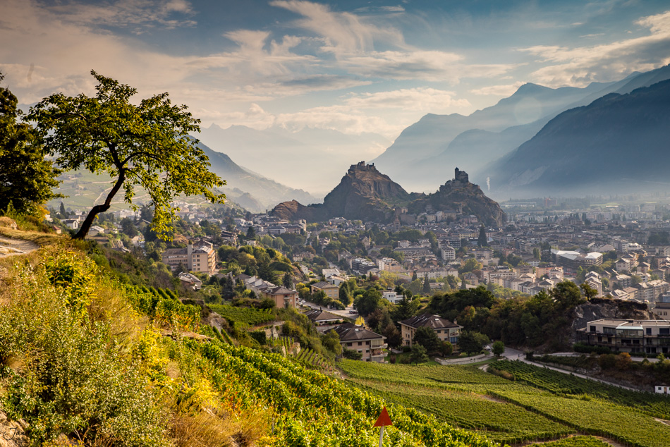 Blick auf Sion mit Schlössern Tourbillon und Valère, herbstliche Berglandschaft im Rhonetal Wallis Schweiz – Jan Geerk Fotograf Basel
