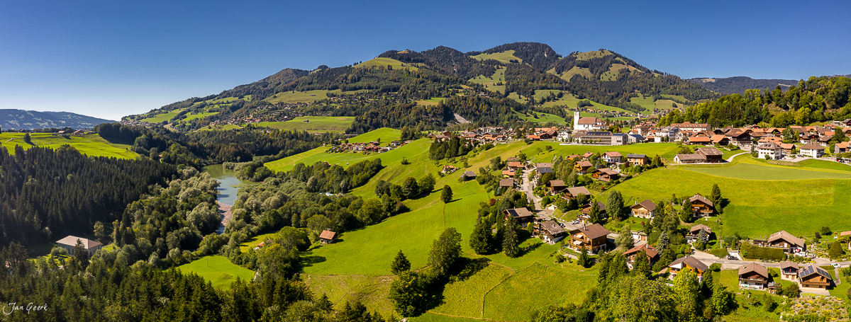 Luftaufnahme Dorf Charmey mit Kirche Wiesen Bergen Sommerlich Freiburg Westschweiz Fotograf Basel
