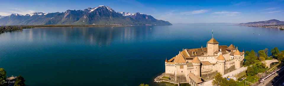 Luftaufnahme Schloss Chillon am Genfersee mit schneebedeckten Alpen im Frühling Waadt Schweiz – Jan Geerk Fotograf Basel