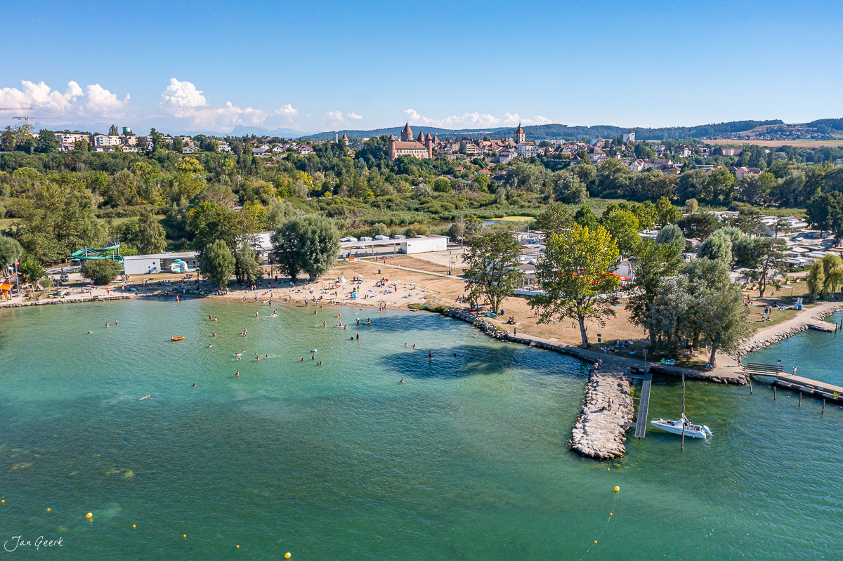 Badestrand und Bootshafen am Neuenburgersee bei Estavayer-le-Lac, klarer Sommertag mit malerischer Altstadt im Hintergrund, Schweiz – Jan Geerk Fotograf Basel