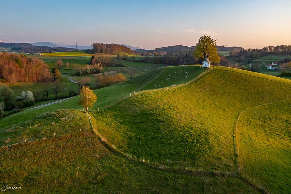 Grüne Hügellandschaft mit Weide und Bauernhaus im Frühling, Mühletal Schweiz – Jan Geerk Fotograf Basel