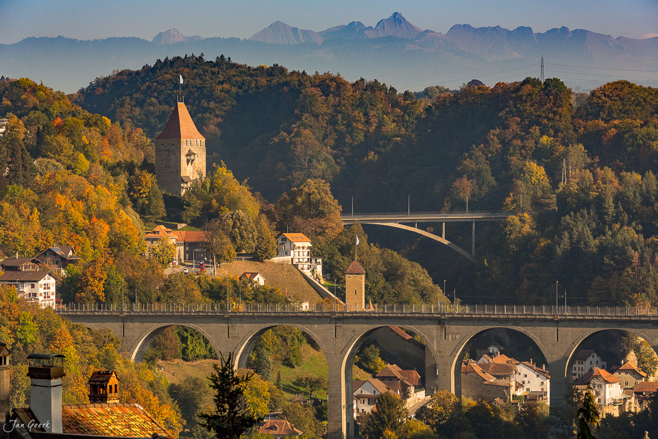 Herbstliche Stadtmauer und Kirchturm von Fribourg mit Herbstlaub, Brücken und Alpenblick – Jan Geerk Fotograf Basel Schweiz
