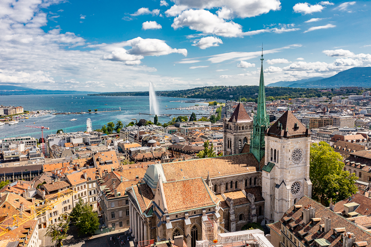 Luftaufnahme der Stadt Genf mit Jet d'Eau und Kirche, blauer Himmel mit Wolken, Westschweiz Schweiz – Jan Geerk Fotograf Basel