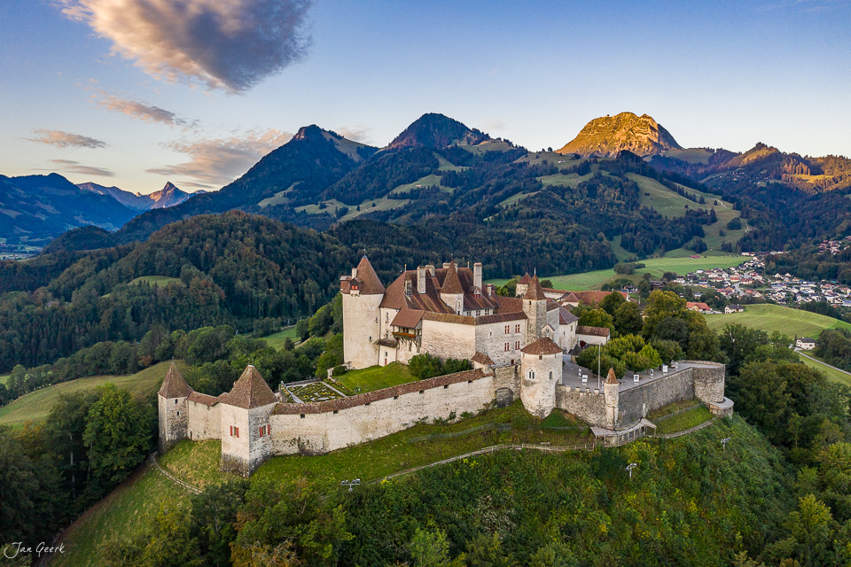 Schloss Gruyères auf grünem Hügel mit Berglandschaft im Sommerlicht, Westschweiz Schweiz – Jan Geerk Fotograf Basel