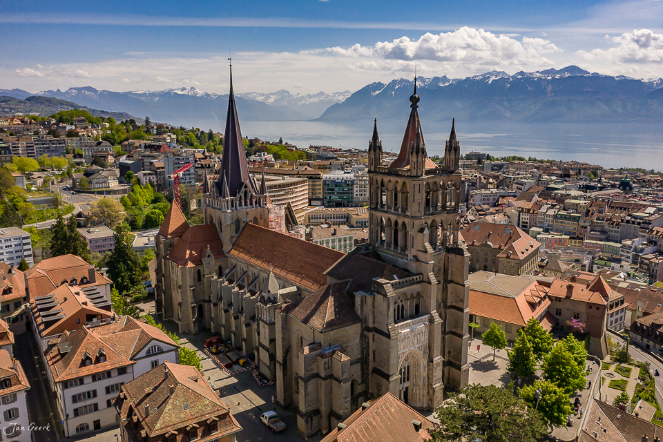 Kathedrale und Stadtansicht von Lausanne mit Genfersee und Alpen im Frühling, Westschweiz, Luftaufnahme – Jan Geerk Fotograf Basel