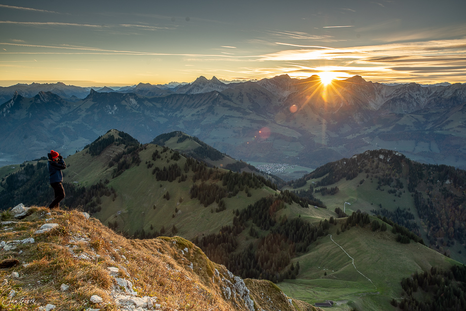 Wanderer auf Felsen beim Sonnenaufgang am Moléson mit Herbstlandschaft Greyerz Westschweiz Schweiz – Jan Geerk Fotograf Basel