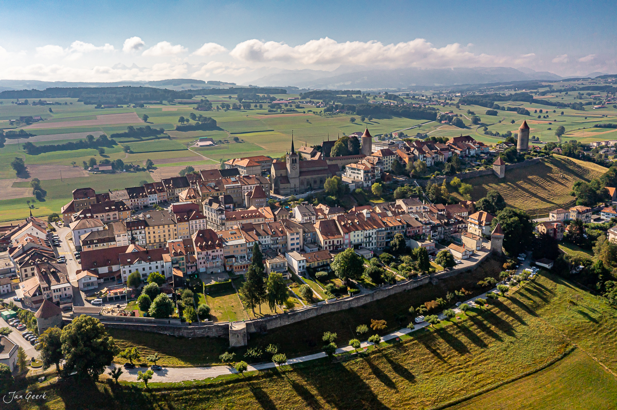 Luftaufnahme der mittelalterlichen Altstadt Romont mit Burgkirche und Stadtmauern, sommerliche Kantlicht-Stimmung, Freiburg Schweiz – Jan Geerk Fotograf Basel