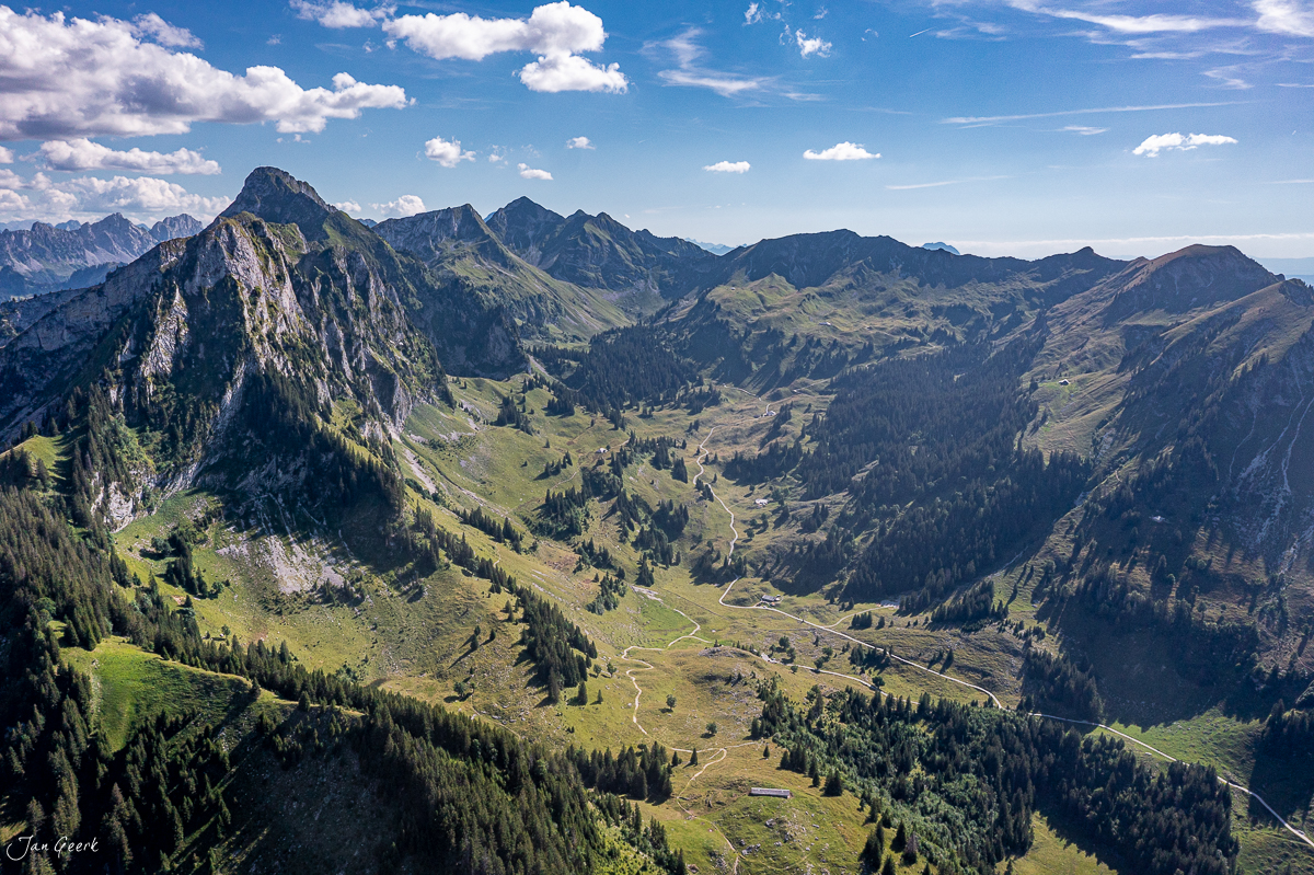 Luftaufnahme des Schwarzsee Tales mit grünen Alpweiden, Felsen und Wäldern, Sommerlicht, Freiburg, Schweiz – Jan Geerk Fotograf Basel