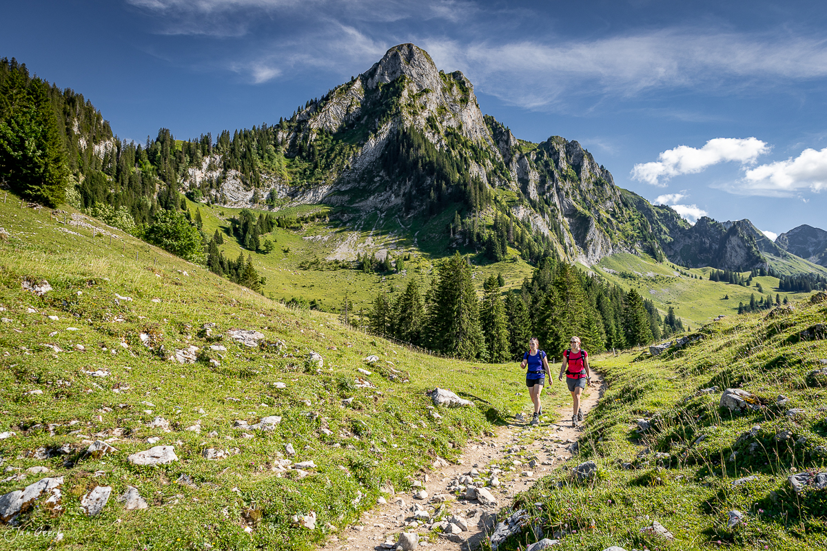 Wanderer auf Bergpfad zum Schwarzsee mit dramatischen Kalkfelsen Sommer Voralpen Schweiz – Jan Geerk Fotograf Basel