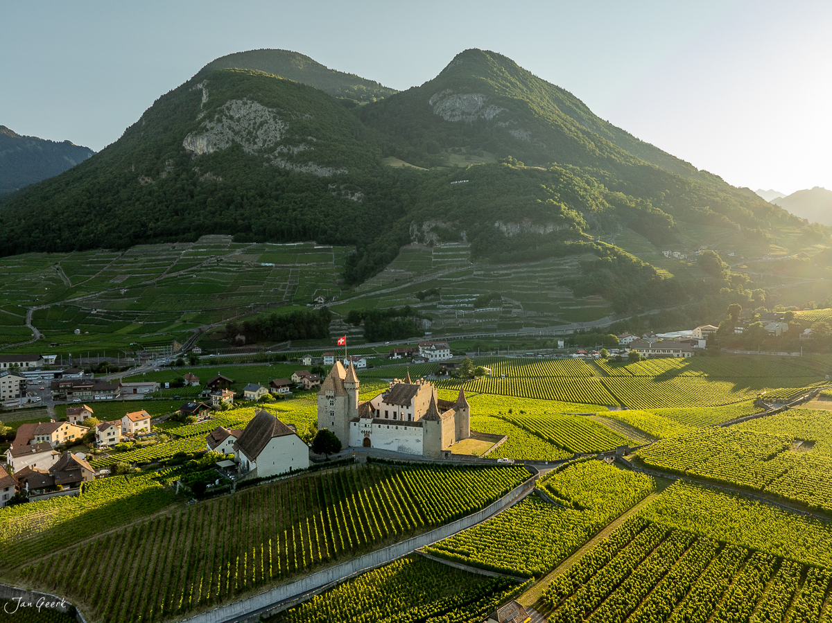 Schloss Aigle mit Weinbergen und Alpen im goldenen Sommerlicht Wallis Schweiz Jan Geerk Fotograf Basel
