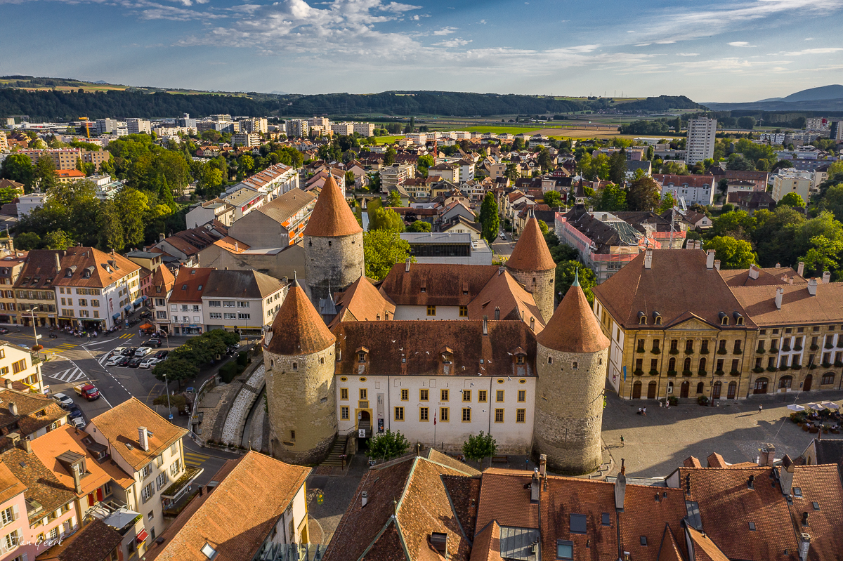 Luftaufnahme Schloss Yverdon mit Altstadt, Türmen und umliegenden Häusern bei Sonnenlicht, Westschweiz – Jan Geerk Fotograf Basel
