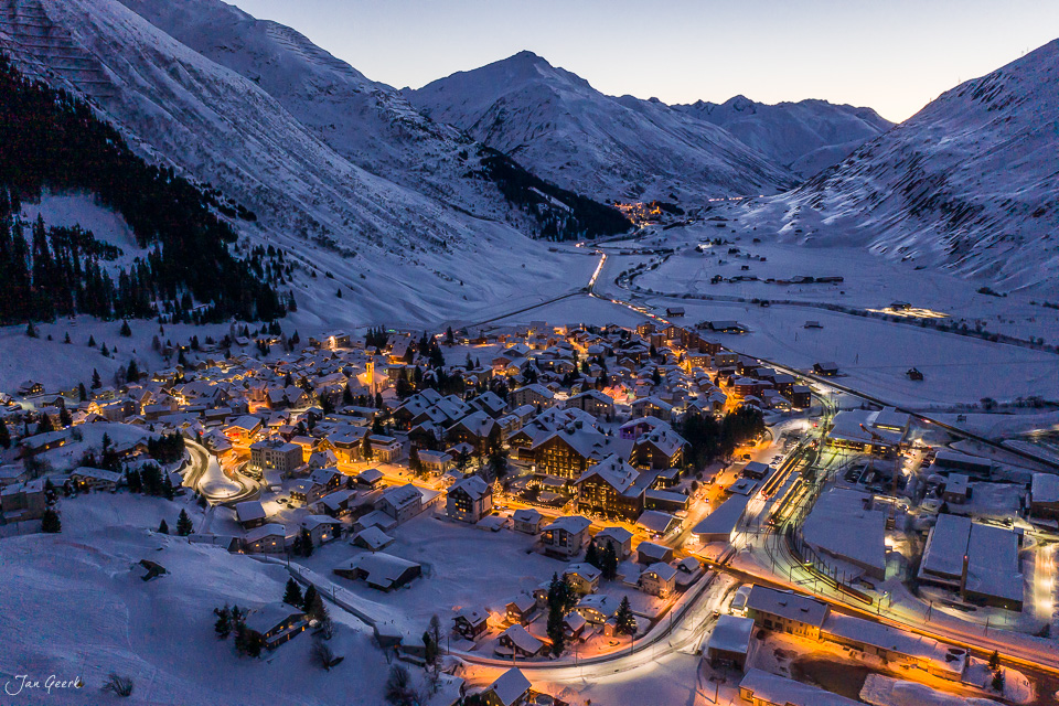 Beleuchtete Bergdorfschaft Andermatt im Schnee bei Dämmerung, Schweiz – Jan Geerk Fotograf Basel