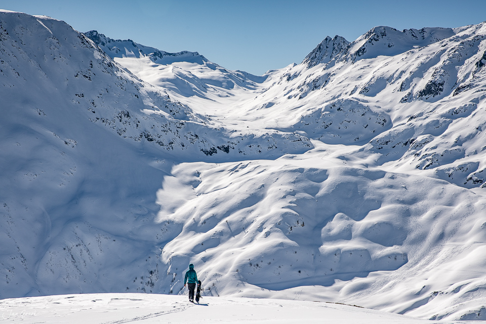 Skitourengeher in verschneiter Berglandschaft beim Oberalppass mit schneebedeckten Gipfeln Wintersonne Schweiz Jan Geerk Fotograf Basel