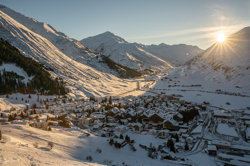 Winterliches Alpendorf Andermatt mit schneebedeckten Bergen im goldenen Sonnenlicht, Zentralschweiz Schweiz – Jan Geerk Fotograf Basel