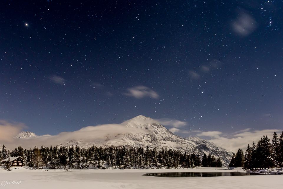Verschneiter Berg mit Wald und gefrorenem See unter Sternenhimmel, Arnisee Zentralschweiz Winter Schweiz – Jan Geerk Fotograf Basel