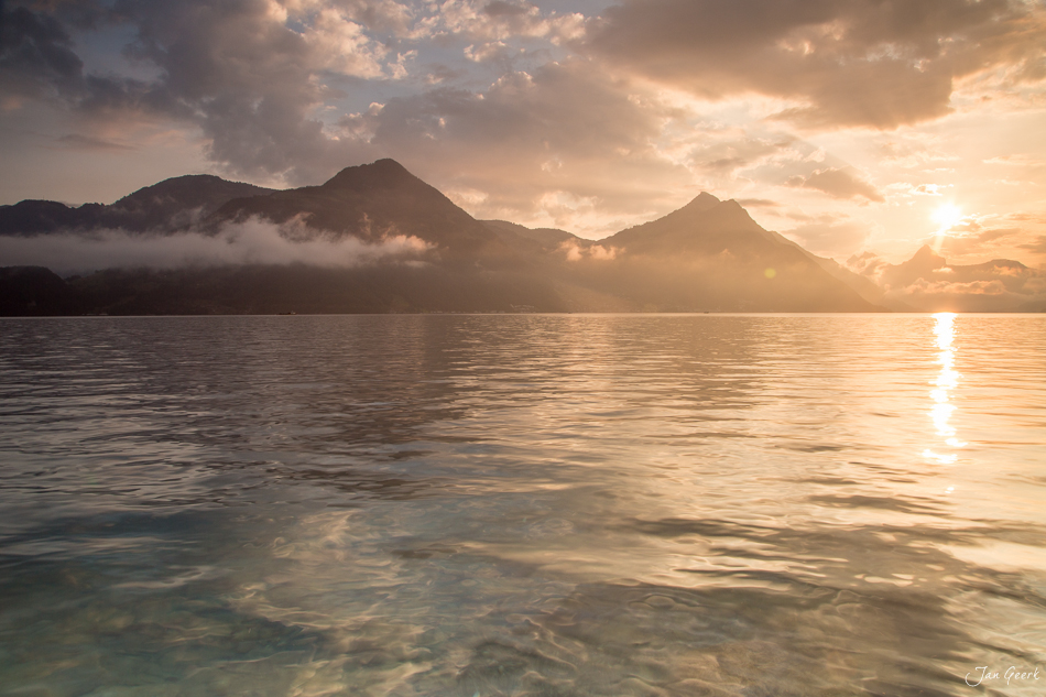 Sonnenaufgang über dem Vierwaldstättersee bei Beckenried mit dramatischen Wolken, Berge spiegeln sich im Wasser, Sommer, Zentralschweiz Schweiz – Jan Geerk Fotograf Basel