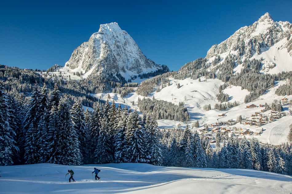 Schneeschuhlaufer auf verschneiter Alp mit Mythen Bergkette im Hintergrund, Brunni Zentralschweiz Winter – Jan Geerk Fotograf Basel