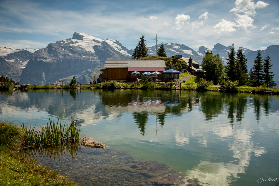Berghütte am See mit schneebedecktem Titlis im Hintergrund, Sommeraufnahme in Engelberg, Zentralschweiz – Jan Geerk Fotograf Basel