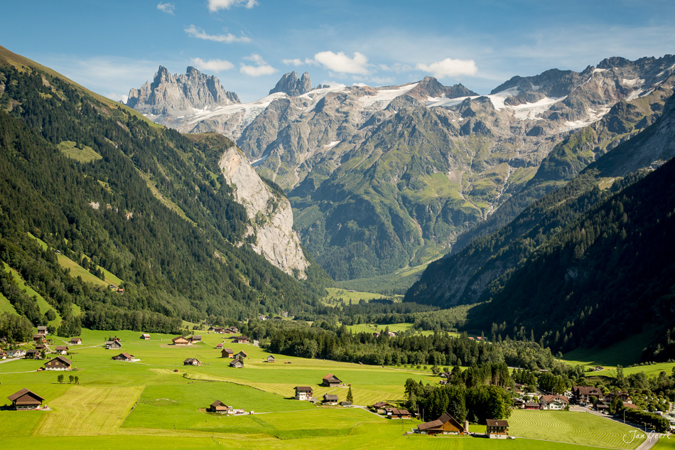 Alpental mit grünen Wiesen, traditionellen Chalets und schneebedeckten Bergen im Sommer in Engelberg, Zentralschweiz – Jan Geerk Fotograf Basel