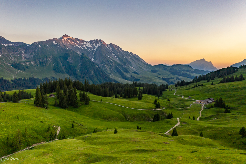 Luftaufnahme der grünen Alpwiesen von Glaubenbielen mit majestätischen Bergen im Hintergrund, Sommer in der Schweiz – Jan Geerk Fotograf Basel