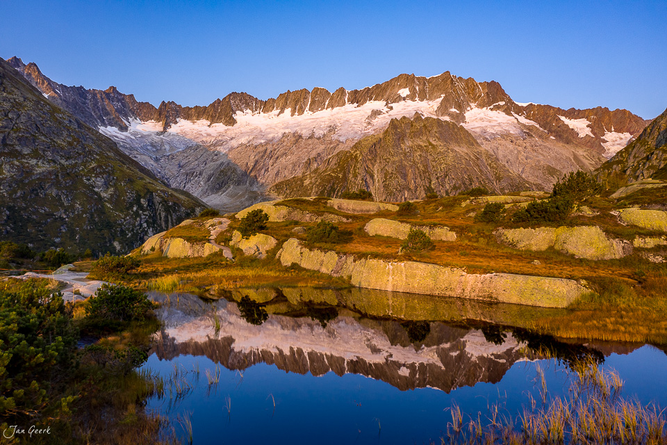 Bergsee mit Spiegelung in der Göscheneralp, schneebedeckte Berggipfel, Herbststimmung, Zentralschweiz – Jan Geerk Fotograf Basel