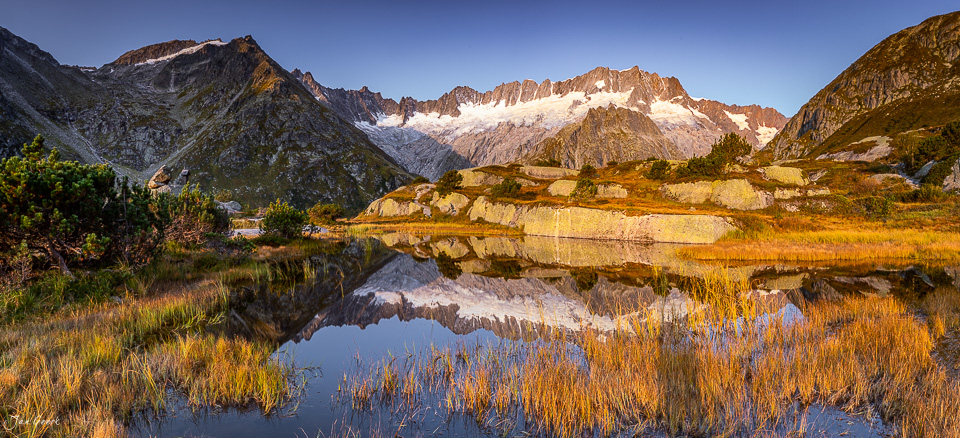Bergsee mit Spiegelung und verschneiten Berggipfeln in der Göscheneralp, Herbstlicht, Uri Schweiz – Jan Geerk Fotograf Basel