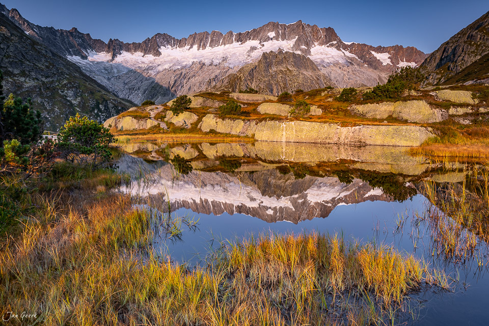 Bergsee mit Spiegelung und verschneiten Bergen in der Göscheneralp, Herbstlicht, Uri, Zentralschweiz – Jan Geerk Fotograf Basel