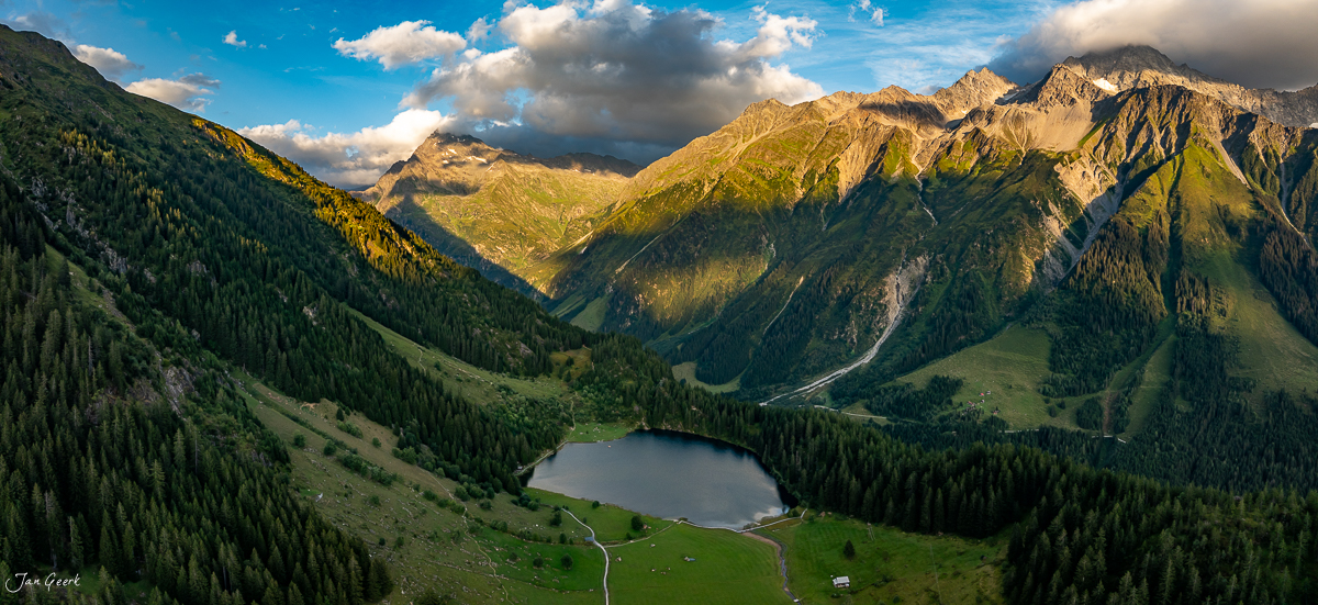 Luftaufnahme Golzernsee mit Bergsee, Alpengipfeln und Lärchenwäldern in Herbstlicht, Maderanertal Uri Schweiz – Jan Geerk Fotograf Basel