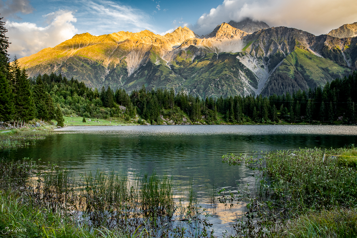 Golzernsee mit alpinem Bergpanorama, grünen Fichten und goldenem Alpenlicht in der Zentralschweiz – Jan Geerk Fotograf Basel