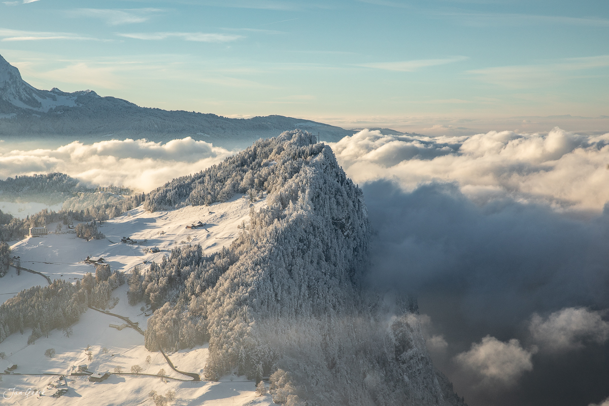 Schneebedeckte Berglandschaft mit Wald über Wolkenmeer im Engelberg bei Kantlicht, Zentralschweiz – Jan Geerk Fotograf Basel
