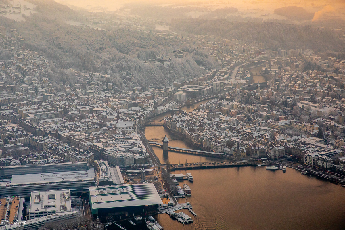 Luftaufnahme der Stadt Luzern am Vierwaldstättersee mit Brücken und Flusswindungen im Morgenlicht, Zentralschweiz – Jan Geerk Fotograf Basel