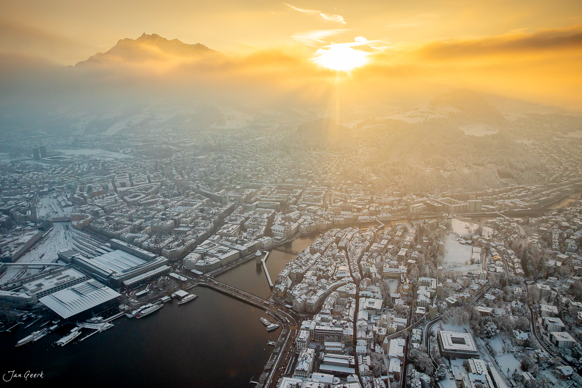 Luftaufnahme Engelberg mit verschneiter Landschaft, Vierwaldstättersee und golden beleuchtete Berggipfel bei Sonnenaufgang, Zentralschweiz – Jan Geerk Fotograf Basel