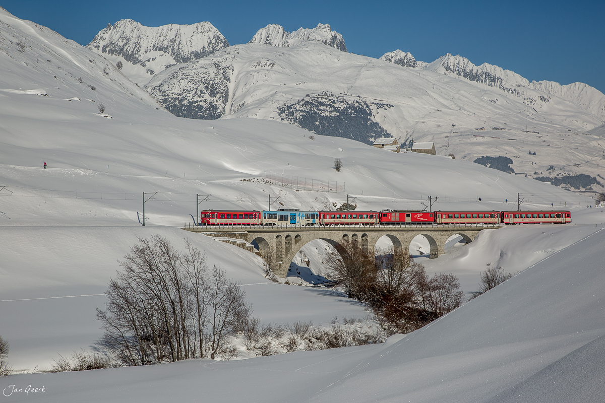 Matterhorn-Gotthard Bahn auf Viadukt bei Hospental im Schnee, Alpen im Hintergrund, Winterlandschaft Zentralschweiz Schweiz – Jan Geerk Fotograf Basel