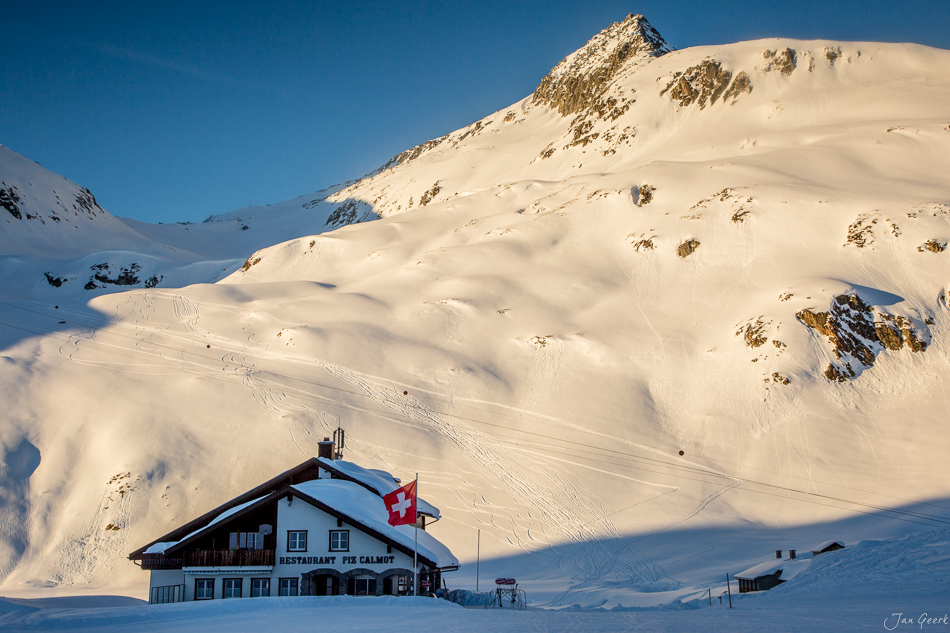 Berghütte Nätschen im Schnee mit Oberalppass im Hintergrund, Winterlandschaft in der Zentralschweiz – Jan Geerk Fotograf Basel
