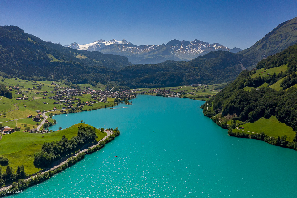 Lungernsee mit türkisblauem Wasser, umgeben von grünen Alpenwiesen und schneebedeckten Bergen im Sommer, Obwalden Zentralschweiz – Jan Geerk Fotograf Basel