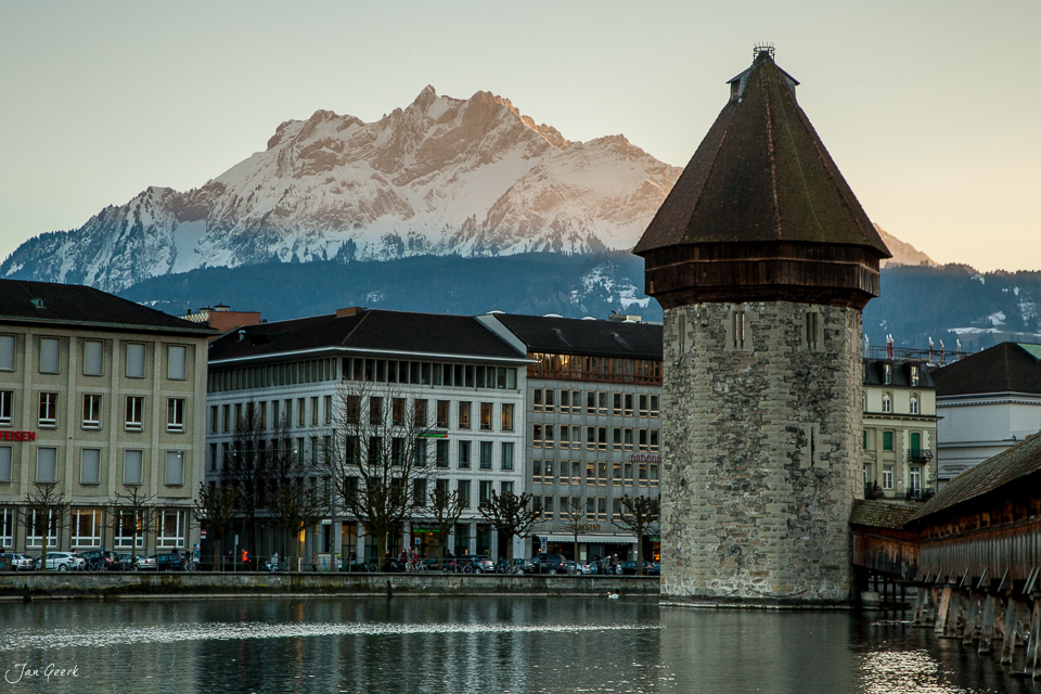 Kapellbrücke und Wasserturm in Luzern im Winter mit schneebedeckten Bergen im Hintergrund – Jan Geerk Fotograf Basel
