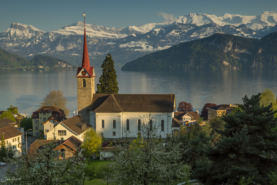 Kirche Weggis mit Vierwaldstättersee und schneebedeckten Alpen im Frühling, Zentralschweiz Schweiz – Jan Geerk Fotograf Basel