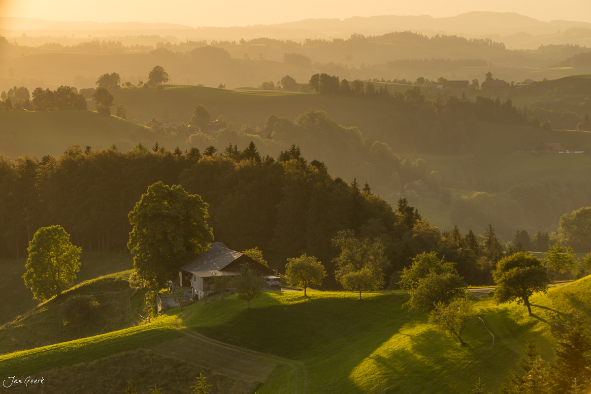 Bauernhaus im Luzerner Hinterland bei goldener Stunde, umgeben von Wäldern und Alpen, Schweiz – Jan Geerk Fotograf Basel