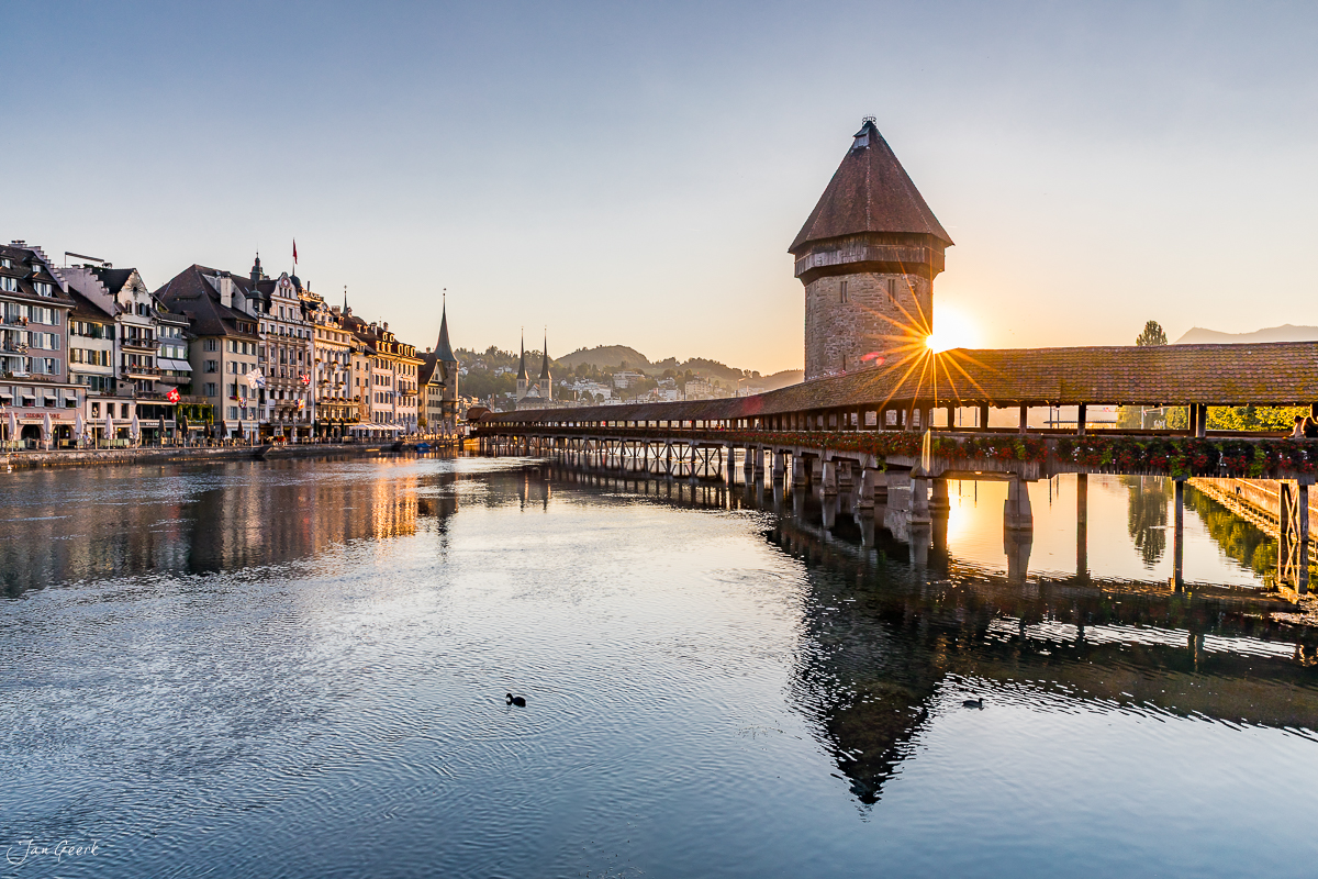 Kapellbrücke Luzern mit Wasserturm bei Sonnenaufgang, Altstadt spiegelt sich im Wasser, Sommer, Zentralschweiz Schweiz – Jan Geerk Fotograf Basel