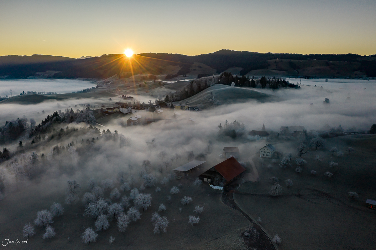 Luftaufnahme Menzingen im Wintermorgen mit dichtem Nebel und Sonnenaufgang Zentralschweiz Schweiz Jan Geerk Fotograf Basel