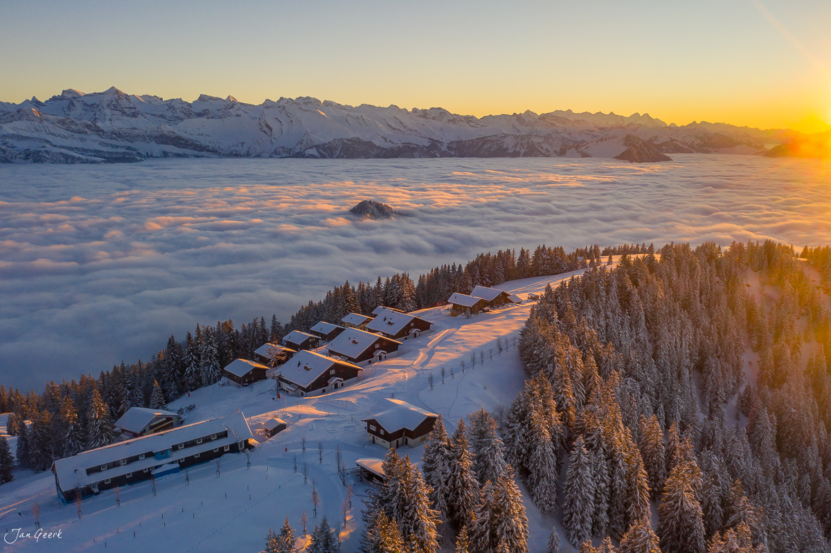 Luftaufnahme Rigi Scheidegg mit schneebedeckten Alphütten, Bergpanorama und Nebelmeer bei Sonnenaufgang im Winter, Zentralschweiz Schweiz – Jan Geerk Fotograf Basel