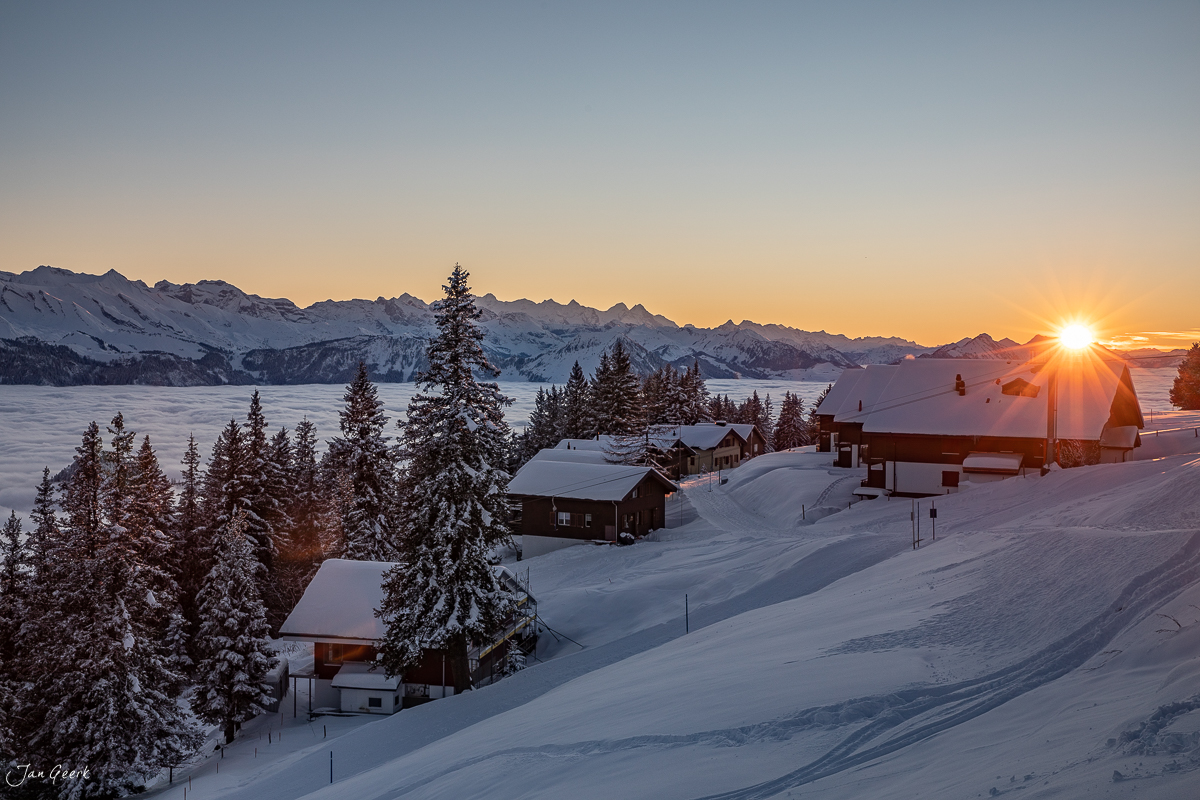 Winterliche Berglandschaft mit verschneiten Häusern und Fichten bei Sonnenaufgang am Rigi Scheidegg in der Zentralschweiz – Jan Geerk Fotograf Basel