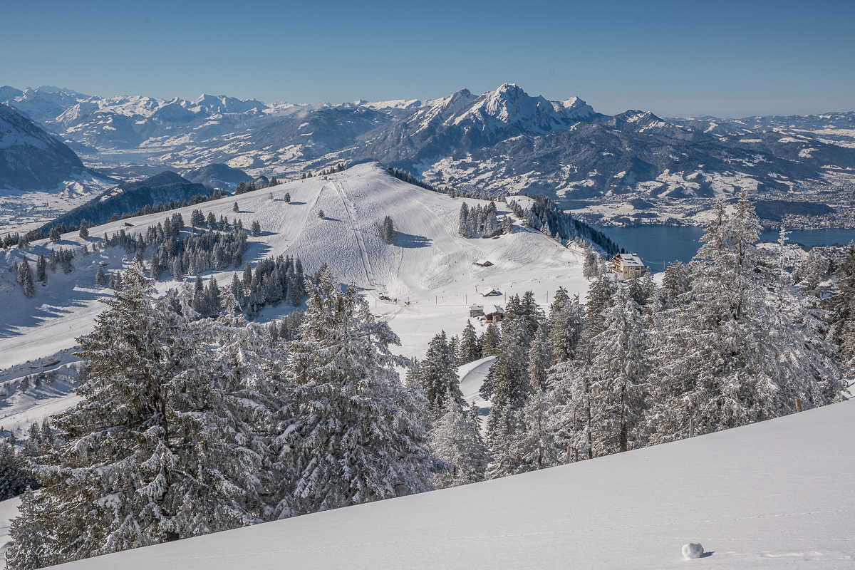 Schneebedeckte Berglandschaft am Rigi mit verschneiten Fichten, See im Tal und Bergen dahinter, Winterstimmung Zentralschweiz – Jan Geerk Fotograf Basel