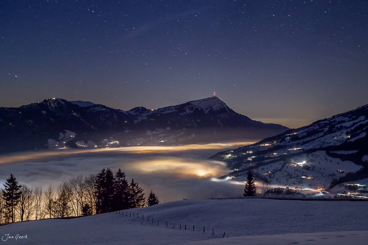Verschneite Alplandschaft Sattel mit Nebelmeer und Berglichtern bei Nacht Zentralschweiz – Jan Geerk Fotograf Basel