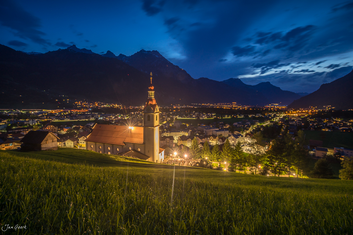 Kirche Schattdorf in der Dämmerung mit beleuchteter Glockenturm über Tal, Zentralschweiz Schweiz – Jan Geerk Fotograf Basel