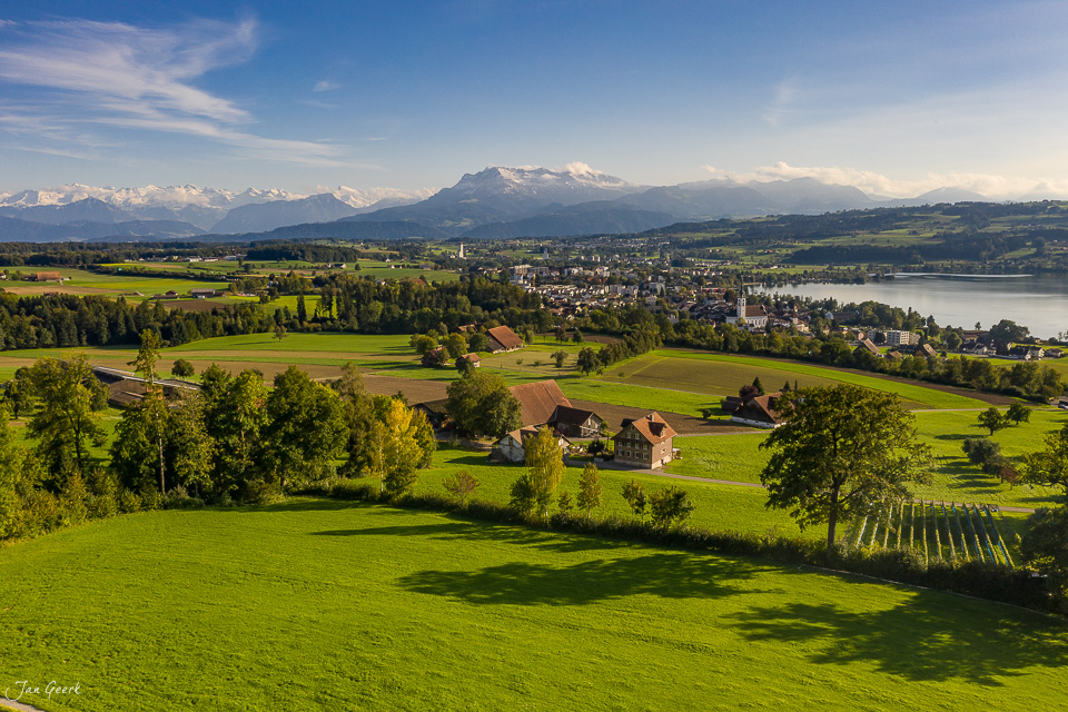 Idyllische Landschaft Sempach mit Bauernhof, See und schneebedecktem Pilatus im Hintergrund, Sommerlicht, Zentralschweiz Schweiz – Jan Geerk Fotograf Basel