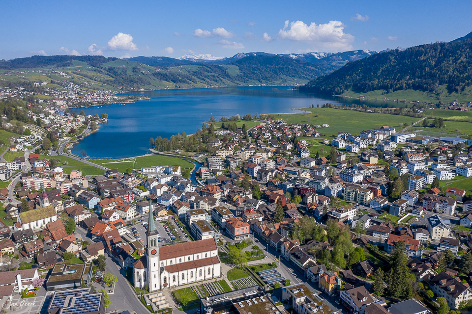 Luftaufnahme Unterägeri See mit Dorf und Bergen im Frühling, Zentralschweiz – Jan Geerk Fotograf Basel
